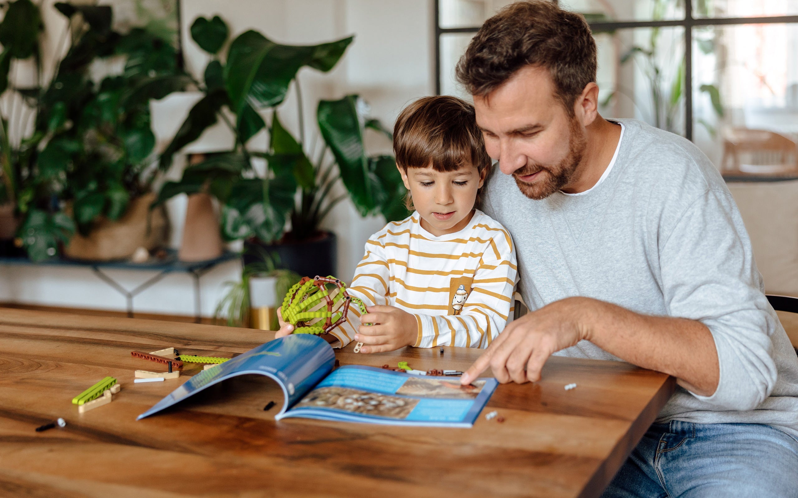 Vater und Kind lesen im Wissensmagazin