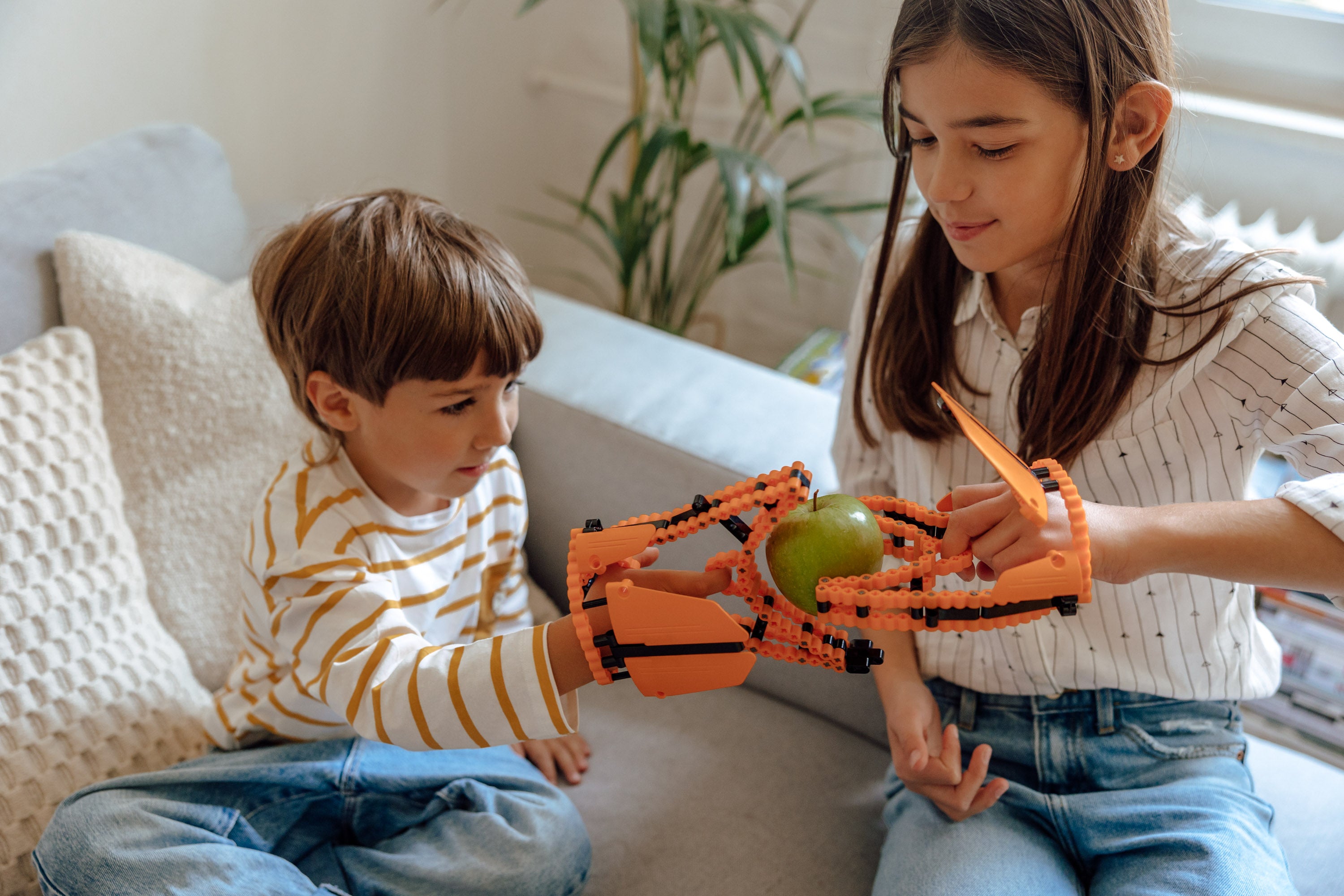 Kinder reichen sich eine Apfel mit der Skorpionschere 