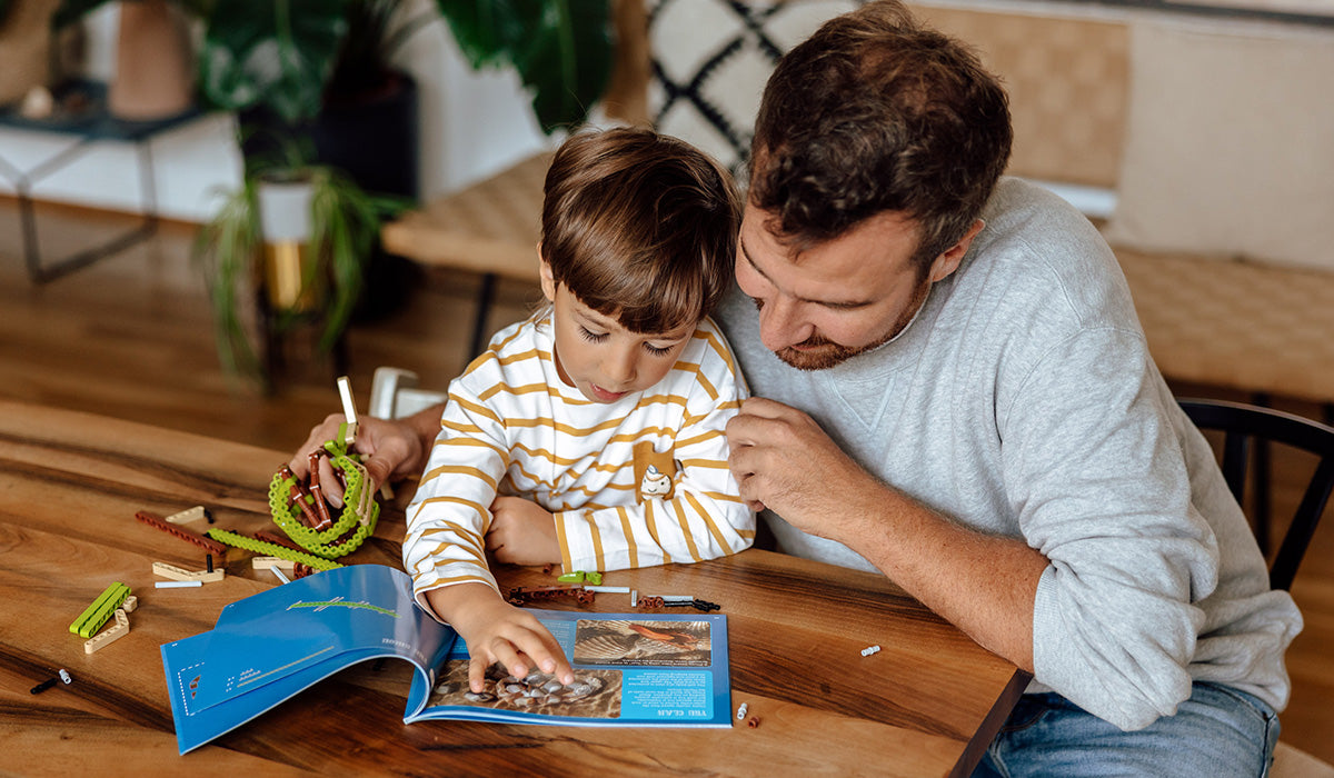 Vater und Junge lesen im Wissensmagazin